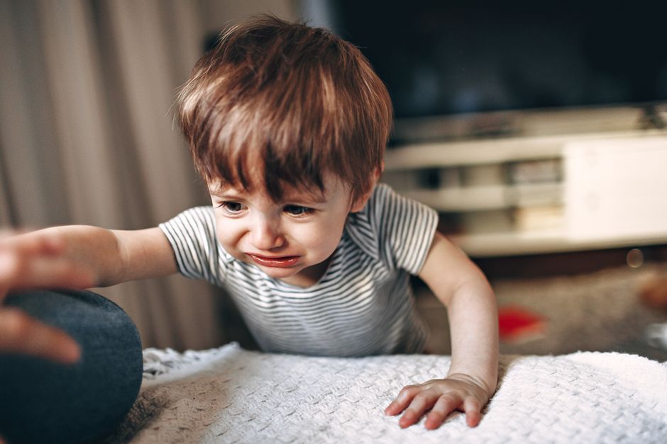 A caring parent gently comforting and connecting with an upset toddler