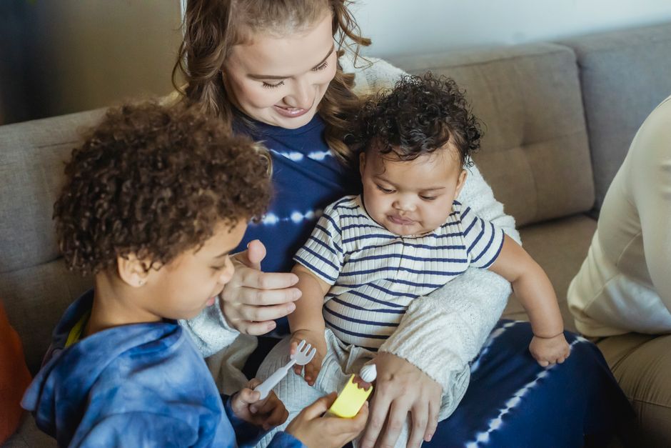 African American boy playing near mother cuddling small baby