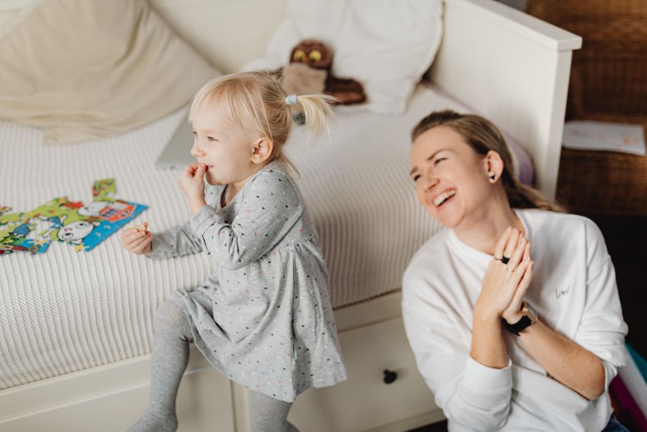 Joyful mother and daughter bonding during playtime indoors. Captured in a cozy home environment