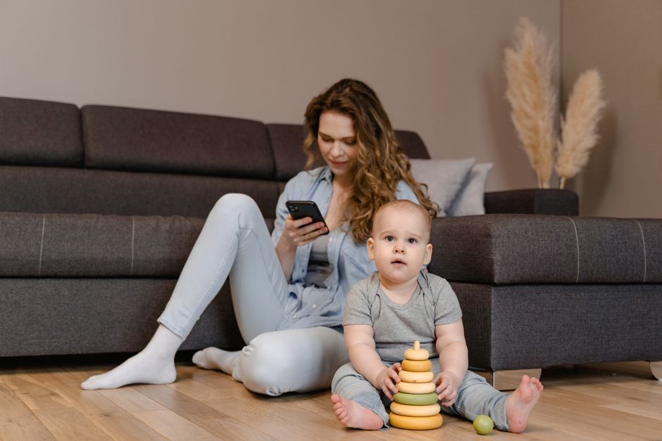 Mother engaging her toddler in focused floor play with responsive facial cues