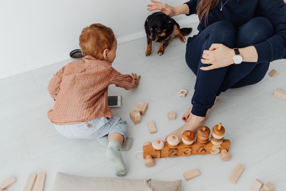 Mother and child building wooden blocks together on the floor