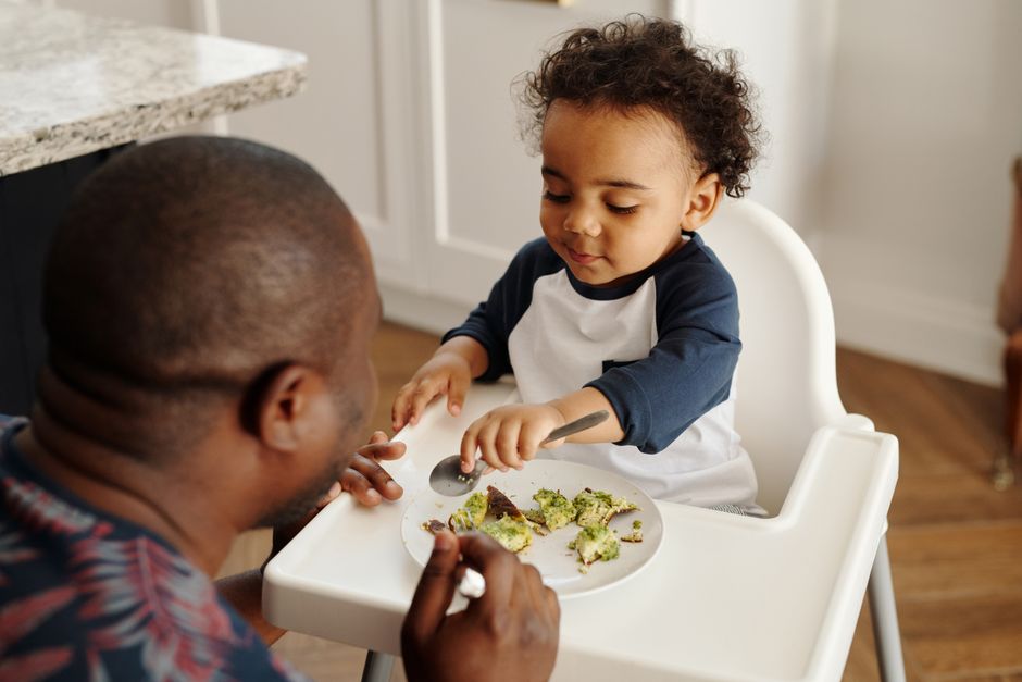 A father and toddler sharing a happy breakfast moment at the table