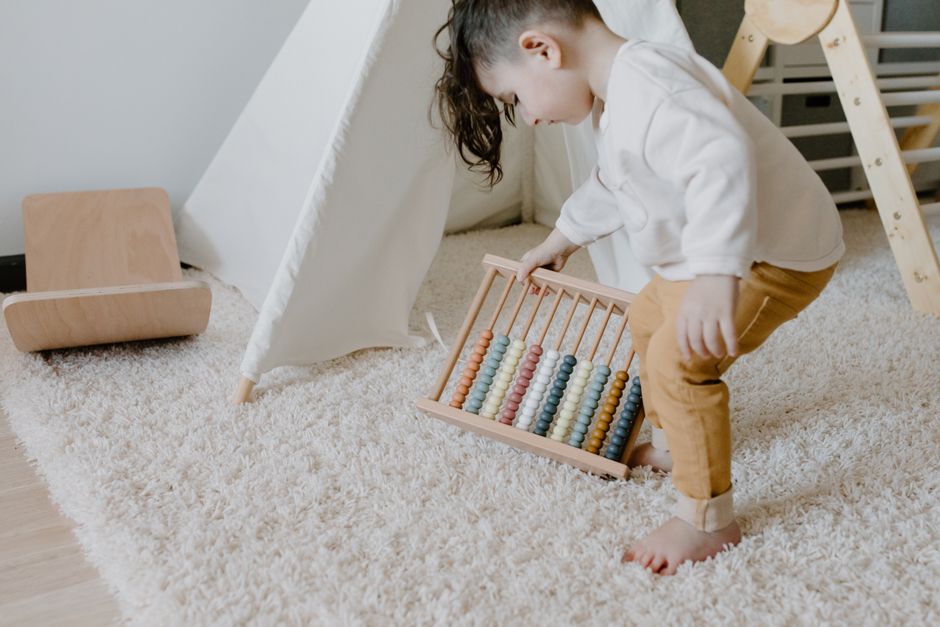 Toddler engaged with sensory toys on the floor developing motor skills