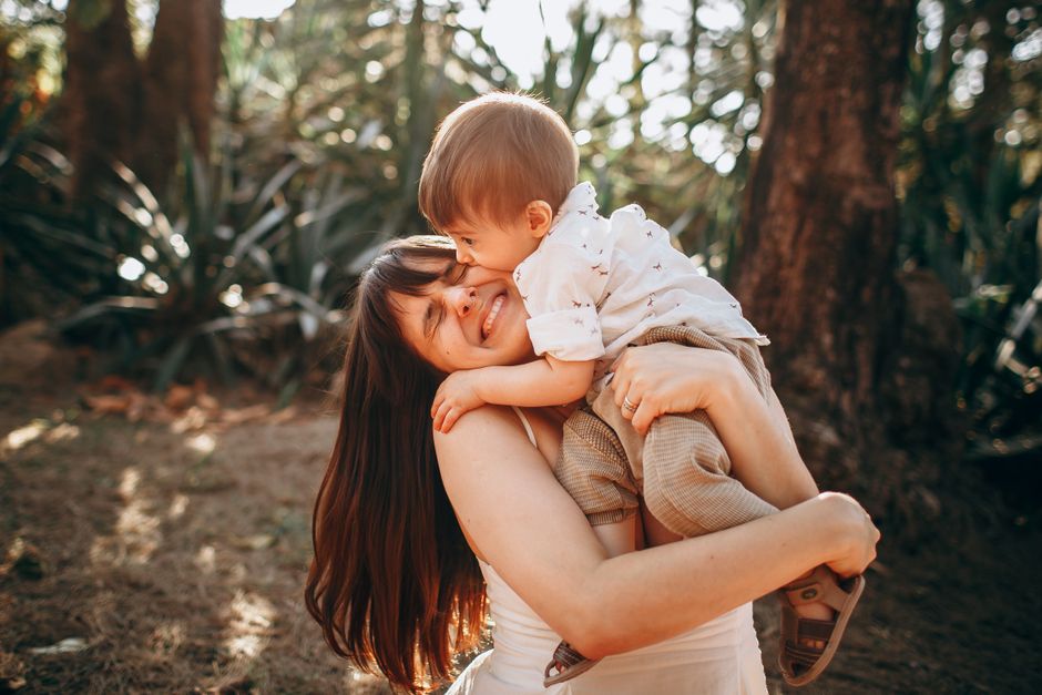Mother and child sharing joyful embrace outdoors in sunlight