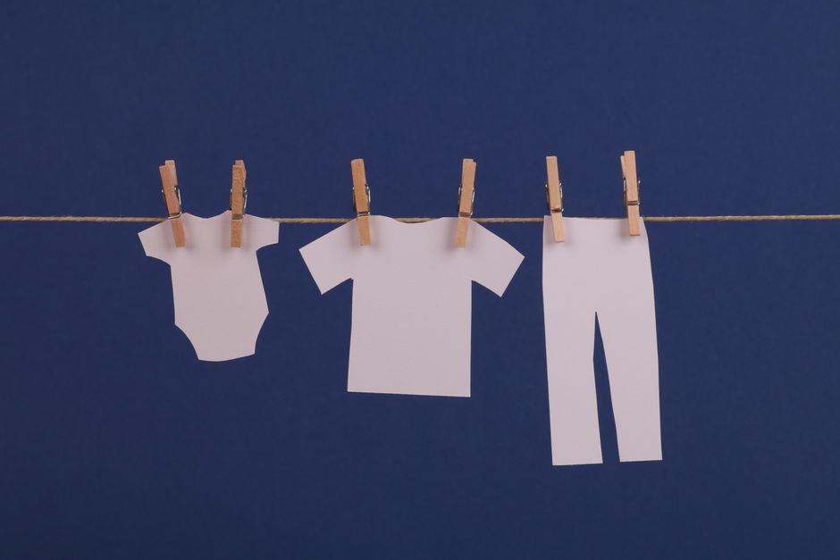 Delicate baby clothes hanging on a line representing clean and safe laundry