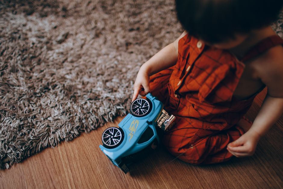 Young toddler happily engaging in healthy floor play on a soft rug