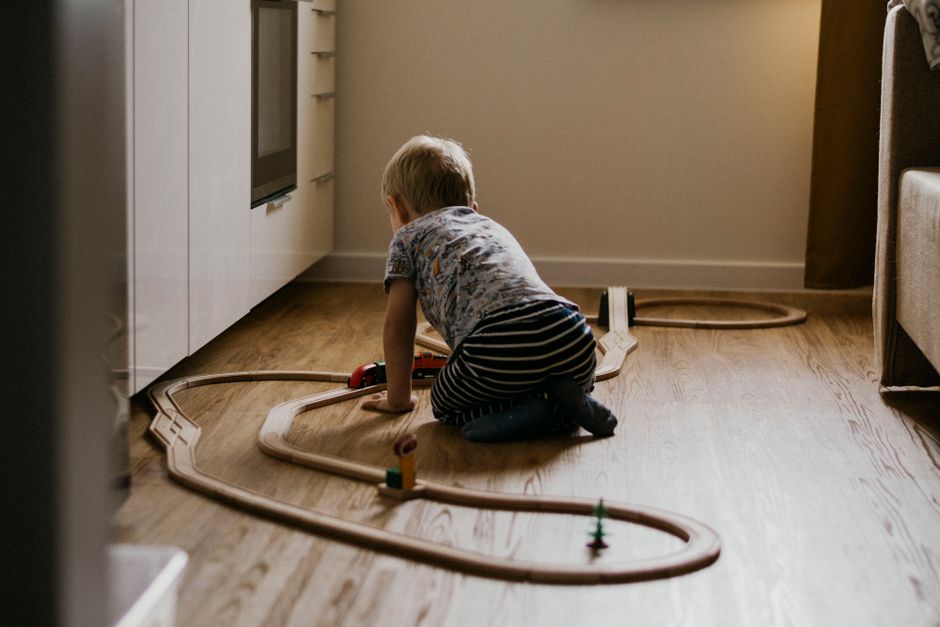 Toddler sitting engaged with toys on carpeted living room