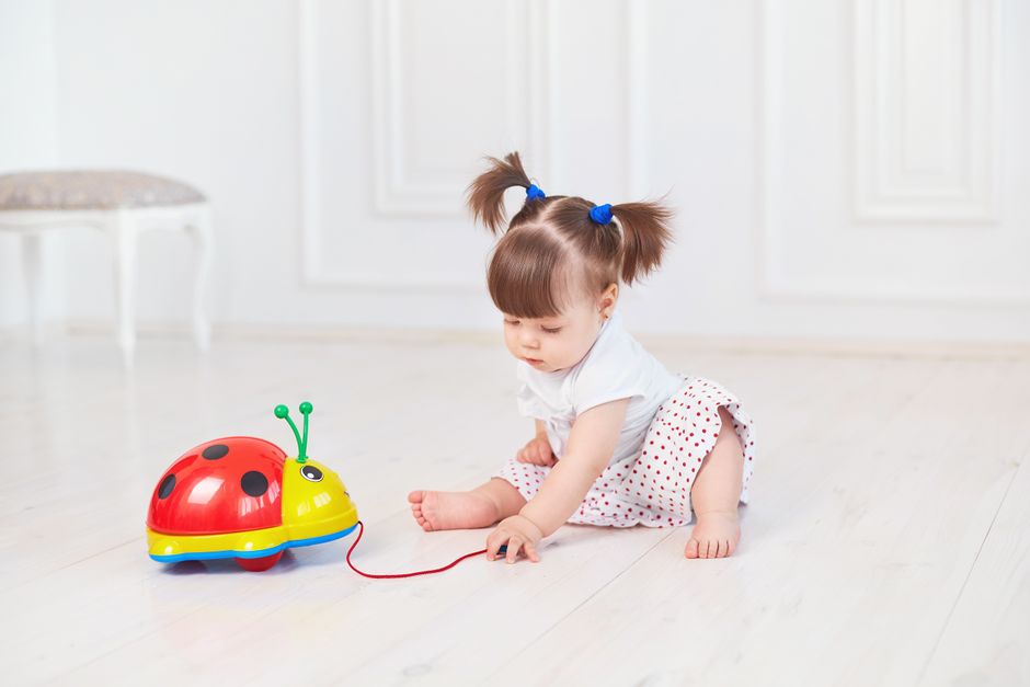 Toddler playing happily with floor toys