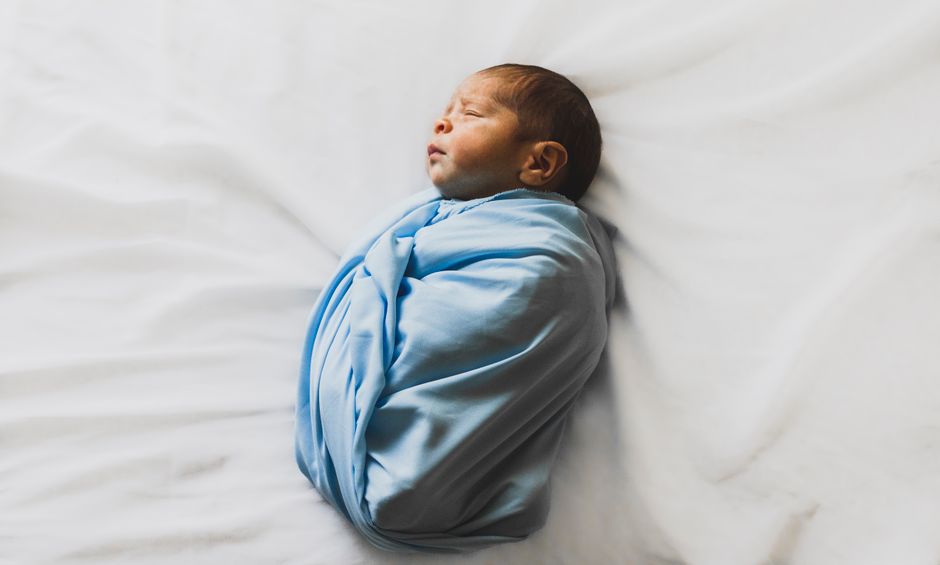 Peacefully sleeping newborn baby wrapped safely in a soft swaddle blanket